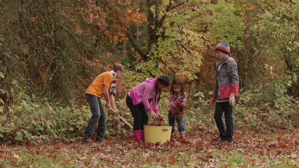 Group of kids in Fall raking leaves