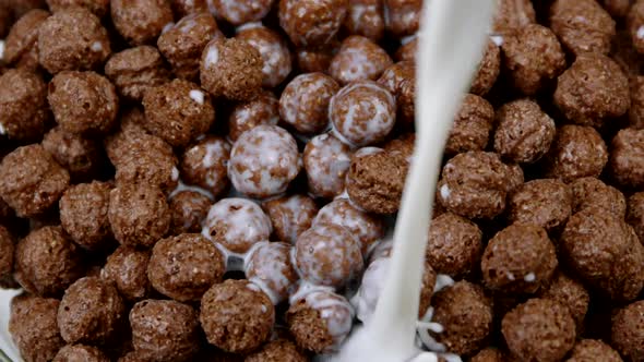 Milk Pouring Into Breakfast Cereals Chocolate Corn Balls Close Up Slow Motion