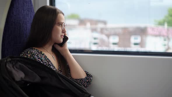 Close Shot of Young Attractive Ukraine Female in Glasses Sitting on Moving City Metro Train alt