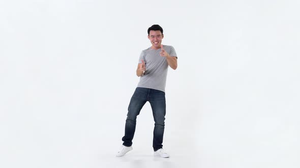 Full length portrait of happy excited young Asian man dancing