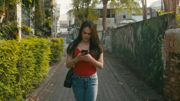a Beautiful Trans Woman Chatting While Walking Down the Street alt