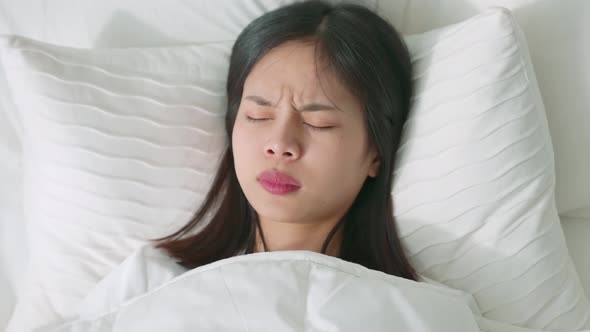 Face of Asian woman in bed at night by nightmares, bad sleep