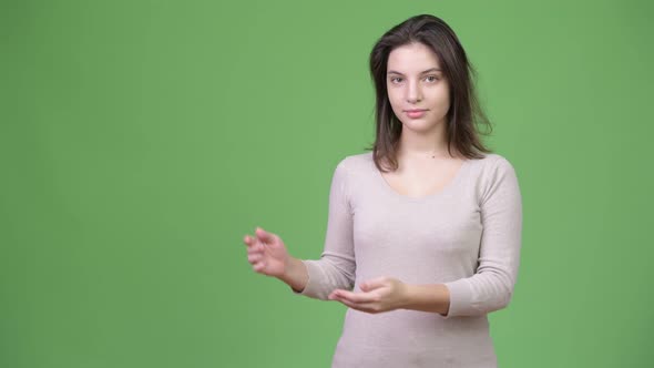 Young Beautiful Woman Showing Something alt