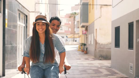 People, leisure and lifestyle concept happy young couple riding bicycle in the city - overjoyed alt