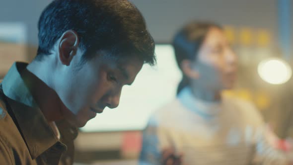 Asia businesspeople stand behind transparent glass wall listen manager pointing progress work. alt