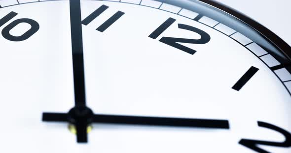 Time lapse on a analog wall clock. Sun and sky reflecting in the surface