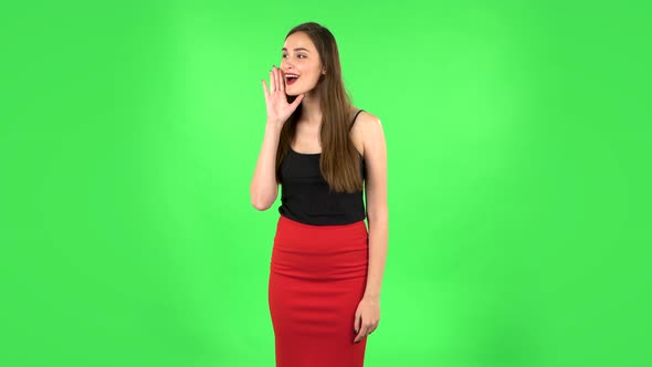 Girl Screams Calling Someone on a Green Screen at Studio alt