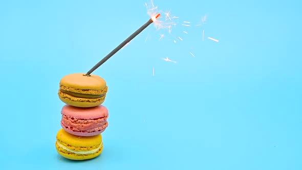 Stack of Delicious Macaron with Burning Sparkle on Blue Pastel Background. Celebrating Concept. alt