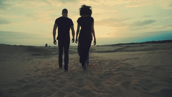 Couple Walking in Desert at Sunset