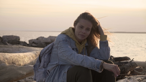 Sad Girl on the Beach Sit and Thinking at Sunset alt