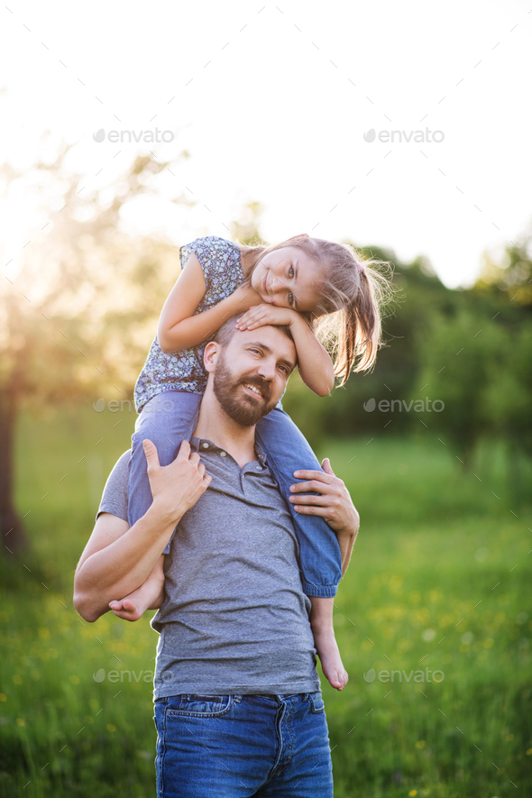 Father giving small daughter a piggyback ride in spring nature. Stock ...