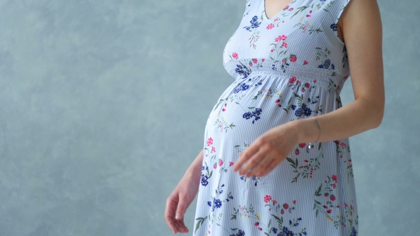 Pregnant Woman Touching Her Belly alt