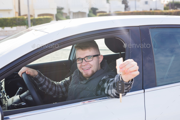 Young man test drive new car and showing key. Car purchase or rental concept Stock Photo by Satura_