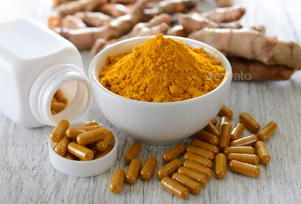 Turmeric powder and turmeric capsules on wooden background Stock Photo by sommai