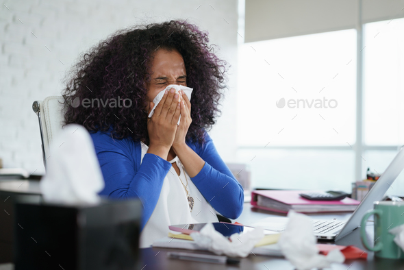 Black Woman Working from Home And Sneezing For Cold Stock Photo by diego_cervo