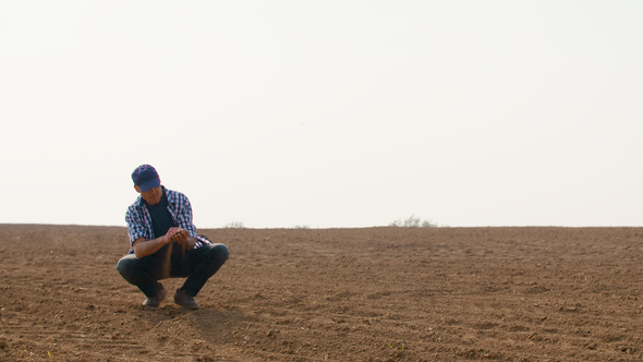 Farmer Examining Soil Quality on Fresh Cultivated Field. alt
