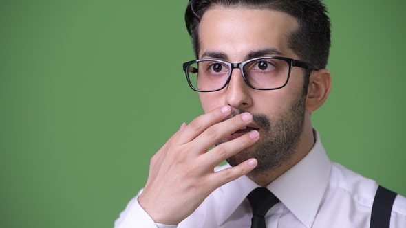 Young Handsome Bearded Persian Businessman Against Green Background alt