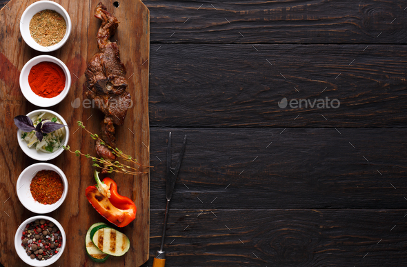 Grilled meat and vegetables on rustic wooden board Stock Photo by Prostock-studio