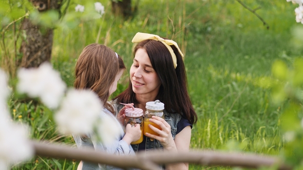 Little Girl Kisses the Young Mother on Nature alt