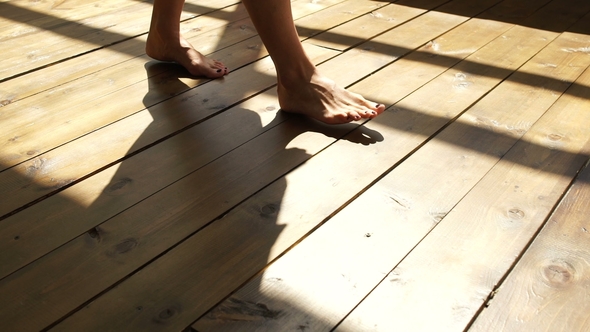 The Girl Walks on the Wooden Floor, Feet in the Sunlight.