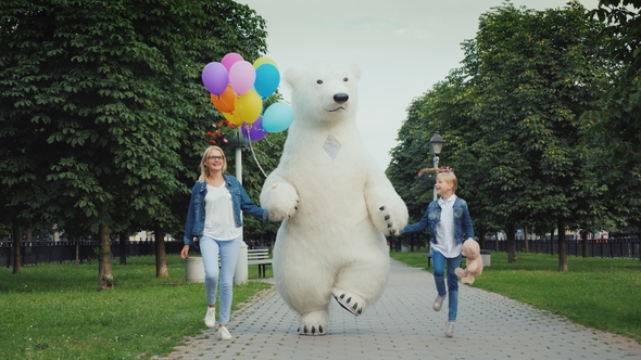 Mom and Daughter and a Polar Bear Are Having Fun Along the Street. Children's Holiday Concept alt