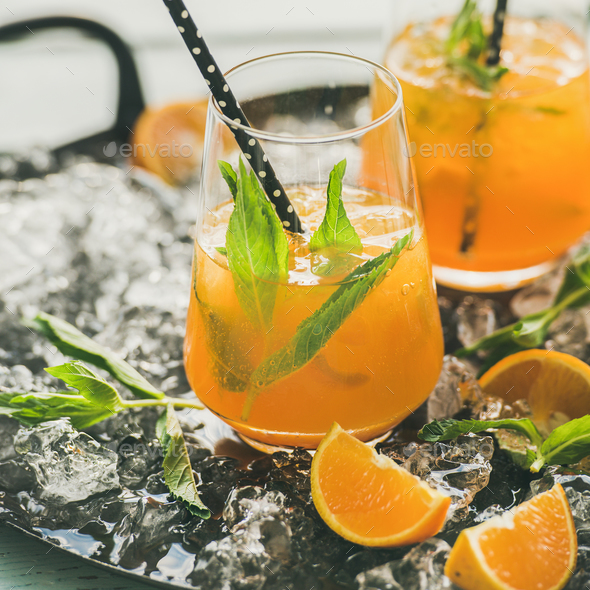 Refreshing cold alcoholic summer cocktail with orange, peppermint and ice - Stock Photo - Images