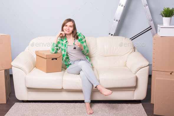 Happy young woman in her new home holding key Stock Photo by Satura_