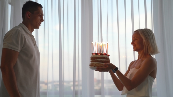 Young Man Blow Out Candles on Birthday Cake alt