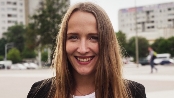 Young Happy Woman with Beautiful Smile, Urban Traffic in Background