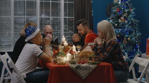 Family Offering Prayers While Celebrating Christmas alt