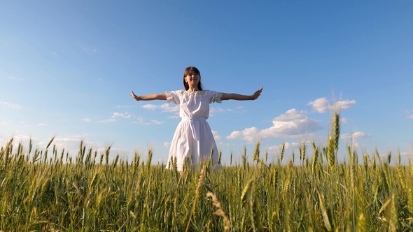 Beautiful Girl with Long Hair Whirls in Flight Stretching Out Her Hands and Smiling in Field with alt