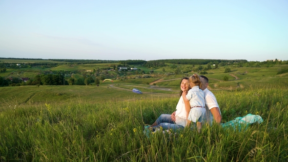 Pregnant Couple with Toddler Daughter Have Leisure Time Outdoors alt