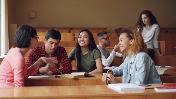 Careless Girls and Boys Are Talking and Laughing Sitting at Desks in Lecture Hall, Students Are alt