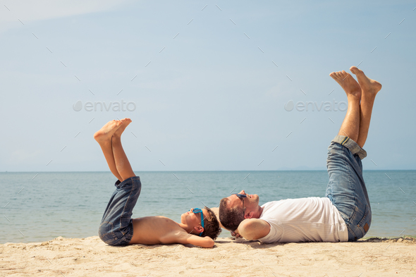 Father and son playing on the beach at the day time. - Stock Photo - Images