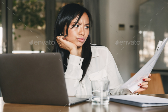 Photo of concentrated asian woman 20s wearing office clothing ho - Stock Photo - Images