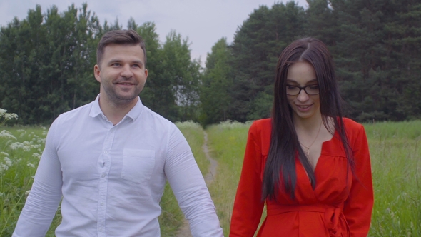 Young Couple Strolling Along the Fresh Air in Nature Holding Each Other By the Hand.