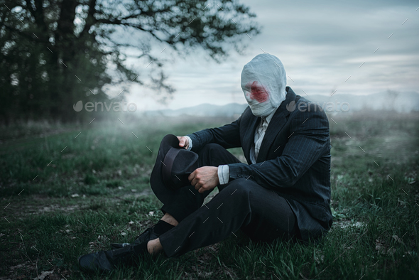 Serial maniac sitting on the ground in forest - Stock Photo - Images
