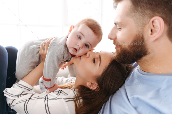 Cute young family. Parents having fun with their little child Stock Photo by vadymvdrobot