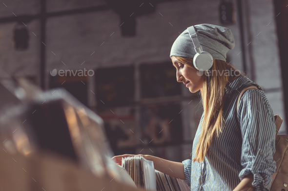 Young girl with headphones in a music store Stock Photo by AboutImages