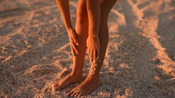 Young Woman Clean Tanned Legs Thin Sticky Seashells Pebbles and Sand