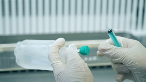 Doctor Picking Up Medication Into a Syringe and Prepares It for Injection alt
