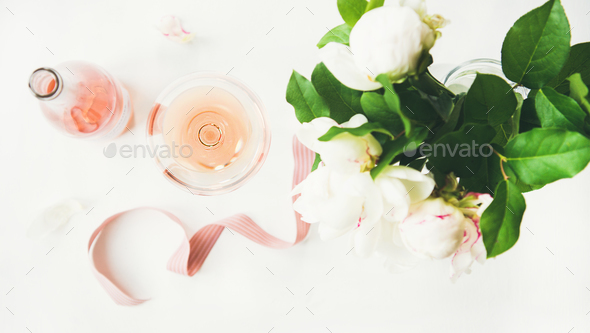 Rose wine, decorative ribbon and peony flowers over white background - Stock Photo - Images
