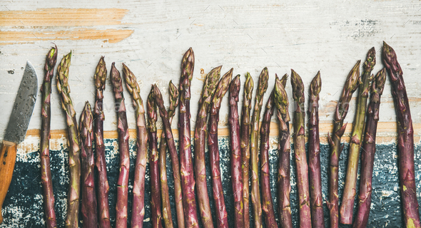 Fresh Raw uncooked purple asparagus over rustic wooden background - Stock Photo - Images