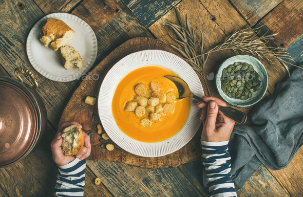 Fall warming pumpkin cream soup with seeds and bread croutons - Stock Photo - Images