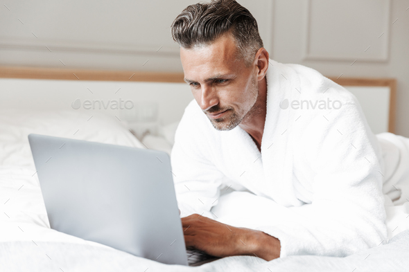 Portrait of masculine adult man with gray beard wearing white ho Stock Photo by vadymvdrobot