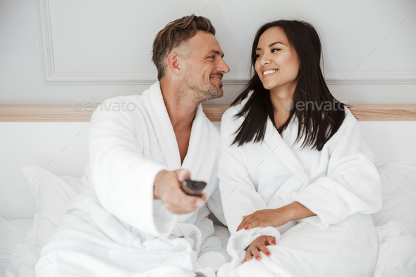 Lovely couple 30s caucasian man and asian woman wearing white ho - Stock Photo - Images