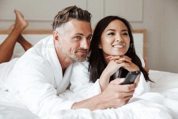 Photo of multiethnic couple man and woman wearing white bathrobe - Stock Photo - Images