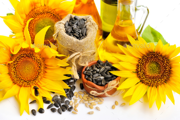 Yellow sunflowers with bottles of oil and a small bag of seeds o Stock Photo by Nataljusja