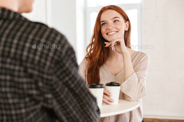 Cheerful friends students drinking coffee talking with each other. - Stock Photo - Images