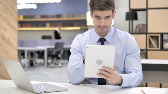 Businessman Using Tablet in Office alt